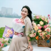 Họa sĩ Phan Anh Thư mang hoa phủ bãi sông Hồng